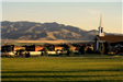 Early Evening and View Church and Homes With Mountains in Background