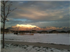 Snow on the Ground Near Residential Area With Mountain Range in Background